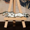 White unicorn enamel pin on mini easel